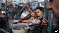Filistinliler Gazze Şeridi'ndeki Cebaliye mülteci kampında yemek sırasında- 18 Mart 2024.