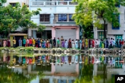 مغربی بنگال کے شہر ہاوڑہ میں لوگ ووٹ ڈالنے کے لیے ایک پولنگ اسٹیشن کے باہر لمبی قطار میں کھڑے ہیں۔ 20 مئی 2024