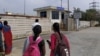 دو خواتین سریپرمبدور میں فاکسکون فیکٹری کے مرکزی دروازے پر سیکیورٹی آفس کے باہر کھڑی ہیں۔فوٹو رائٹرز
