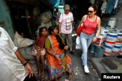 28 Kasım 2007: Turistler Asya'nın en büyük gecekondu mahallelerinden biri olan Dharavi'de rehberli bir tur sırasında yürüşte.