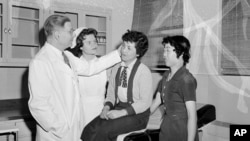 9 Mayıs 1955 - New York’taki Mount Sinai Hastanesi’nde plastik cerrah Dr. Arthur Barsky ve öğrencisi Eleanore Kupencow, Hiroşima’daki atom bombası patlaması sonucu yaralanan iki Japon kadın, Toyoka Minowa ve Miiçiko Sako’yu geçirecekleri ameliyat öncesinde muayene ediyor.