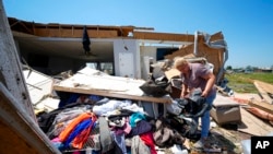 Teksas'ta evi şiddetli fırtınada büyük hasar gören Juana Landeros, enkaz altında kalan eşyalarını toplamaya çalışıyor.