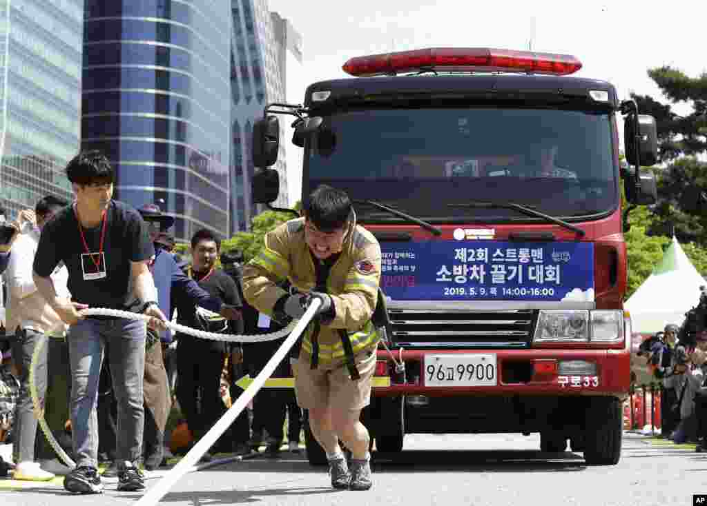 Seul&#39;de düzenlenen Güvenlik Festivali&#39;nde Güney Koreli itfaiyeci aracını halatla çekerken.&nbsp;