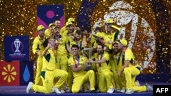 Australia's players celebrate with the trophy after winning the 2023 ICC Men's Cricket World Cup one-day international (ODI) final match against India at the Narendra Modi Stadium in Ahmedabad on November 19, 2023. (Photo by Punit PARANJPE / AFP) / -- IMA